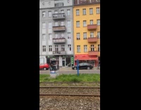 Woman wearing costume sits in front shop 