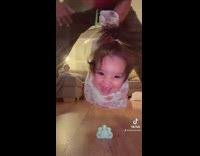 Baby lowered down to pick up binky in mouth 