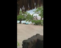 Woman in red bikini sit and poses at the beach