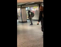 Girl holds one arm up subway station 