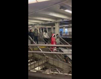Woman wears red cloak with fur on subway 