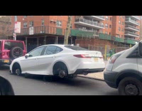 Car parked on street with stolen tires