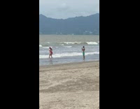 Woman in red bikini poses on the beach shore