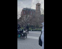 Man with tv on head walks down park