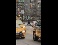 Man stands with legs spread and holds up the cross in front of traffic