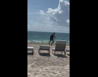 Man pretends to lasso the drone at the beach