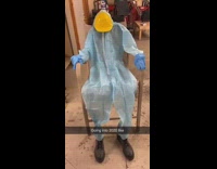 Blue hazmat suit yellow hardhat sits chair 