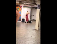 Woman lip syncing performs at train station 