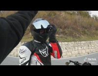 Two bikers waiting for traffic light slapping each other helmet