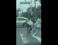Woman cross guard dances as people cross