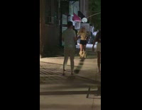 Girl walking down street bags on feet.
