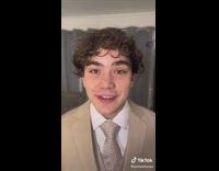 Man in brown suit says the intro of the Daily Dose of Internet