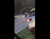 Girl sits curvy mountain road white SUV 
