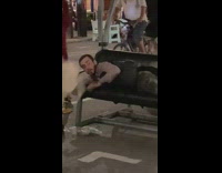 Dog jumps on guy laying on bench 