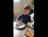 Kid stuffing mouth with peanut butter sandwich