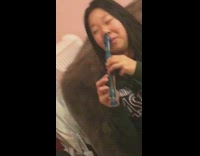 girl plays blue flute with her nose