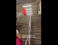 Man on subway station wearing superman costume