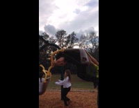 a kid in black falls off a assisted swing