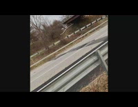 Guy watches cars drive over big hole in ground