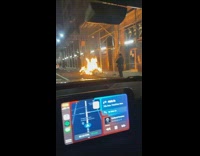 Recording of a trash on fire on the sidewalk