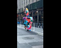 Collab WINY - Man carrying piles of clothes while walking