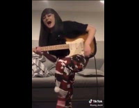 Girl playing electric guitar screams