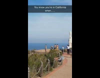 Shirtless man handstand on ledge mountain overlooking