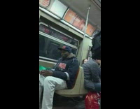 Artist plays Love Yourself on drums while man smokes on subway train