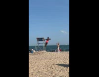 Woman pink swimsuit hang on lifeguard post