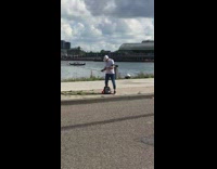 Man selfie stick sidewalk nike bag boat