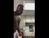 Guy breaks frozen pizza in half with his head in kitchen