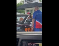 Woman MAGA hat films at gas station