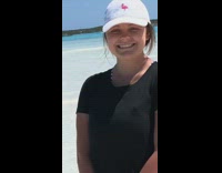 Two girls lay intimately on beach for photo