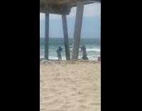 Woman in bikini raise both hands under the bridge