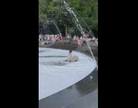 Man in white outfit in foamy water fountain