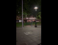 Man green top poses beside park bench