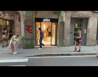 Woman in black crop top and heel sandals poses on the sidewalk