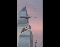 Two black helicopters high rise building sunset