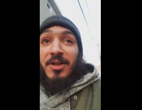 Guy in green jacket walks home with pizza and drinks