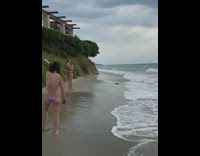 Black dress girl walks out ocean water 