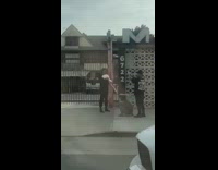 Guy poses with electric guitar outside house 