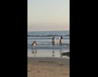 Two women synchronized hair flip at the beach
