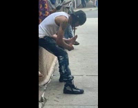 Guy gives lady foot massage on sidewalk 