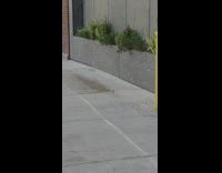 Water dripping off of balcony of apartments onto sidewalk