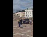 Woman black leather bikini kneels on top of racecar
