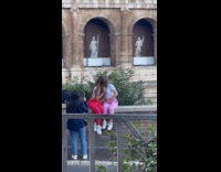 Two women kisses front of the Colosseum