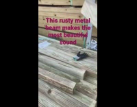 Man hits the metal beam with lumber and produces sound