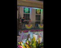Lady in White Dress Poses as she Leans on Balcony