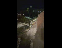 Girl sits inside snow igloo with bonfire 