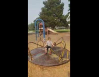 Guy falls off merry go round playground 
